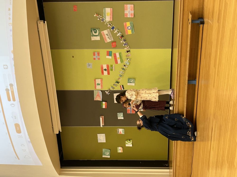 en person som står foran en grønn tavle med bilder på